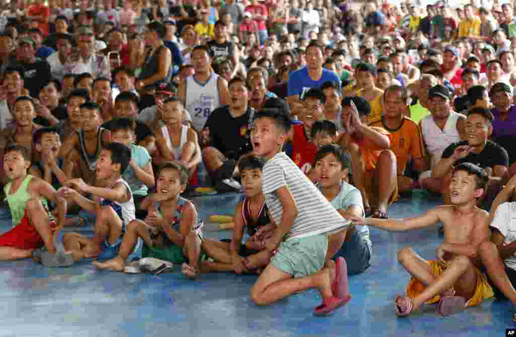 Fans react during the WBA Welterweight Championship boxing match between Filipino Manny Pacquiao and American Adrien Broner, in Manila, Philippines, which was live via satellite from Las Vegas. Pacquiao retained the title via unanimous decision.