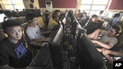 People use computers at an internet cafe in Hefei, Anhui province (September 2011)