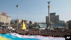 FILE - People hold Ukrainian, Crimean and Crimean Tatar flags during rally in support of Ukraine's territorial integrity, in Kyiv's Independence Square, March 23, 2014.