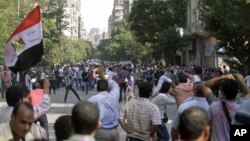 Protesters try to stop the stone throwing after scuffles broke out between groups of several hundred protesters in Tahrir square when chants against the new Islamist president angered some in the crowd in Cairo, Egypt, October 12, 2012.