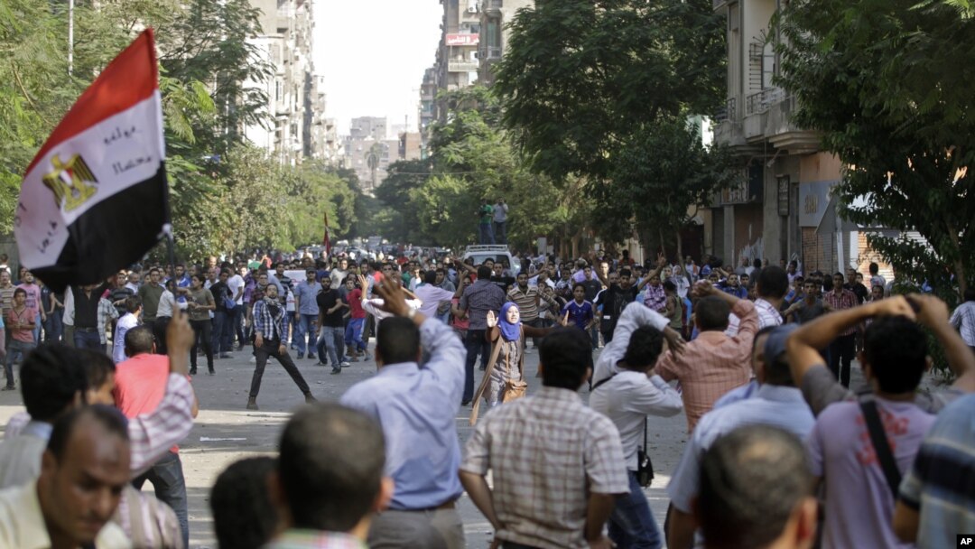 Massa pendukung Presiden Morsi dan penentangnya saling melempar batu di Lapangan Tahrir, Kairo (12/10).