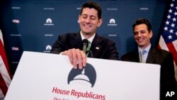 House Speaker Paul Ryan of Wis., center, accompanied by Rep. Tom Graves, R-Ga., tries to fix a sign on his podium after a cameraman bumped it during a news conference following a GOP caucus meeting on Capitol Hill, Wednesday, Sept. 13, 2017, in Washington