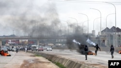 Policemen shoot canister of tear gas to disperse people during a demonstration and attacks against South Africa's owned shops in Abuja, Nigeria, Sept. 4, 2019.
