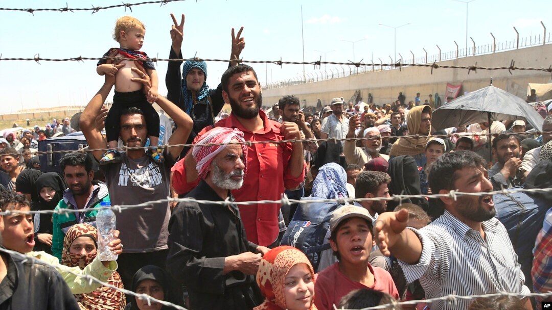 Người tị nạn Syria tập trung tại biên giới Thổ Nhĩ Kỳ khi chạy trốn giao tranh dữ dội ở miền bắc Syria giữa các chiến binh người Kurd và các chiến binh Hồi giáo ở Akcakale, đông nam Thổ Nhĩ Kỳ, ngày 15 tháng 6 năm 2015.