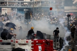 Protesters react to a tear gas during a demonstration against a proposed extradition bill in Hong Kong, June 12, 2018.