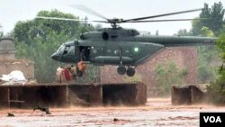 Petugas pertolongan berusaha mengevakuasi penduduk yang terjebak akibat bencana banjir.