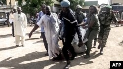 Security forces transport with a blanket the remains of some of the 11 victims of a double blast in the northern Cameroonian city of Maroua, July 22, 2015. 