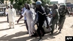 Les forces de sécurité transportent dans une couverture les restes d’un victime d’explosion dans le nord de la ville de Maroua, Cameroun, 22 juillet 2015.