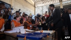 Le candidat à la présidence de Podemos, Venancio Mondlane (d), arrive pour voter dans un bureau de vote à Maputo le 9 octobre 2024 lors des élections générales au Mozambique. 