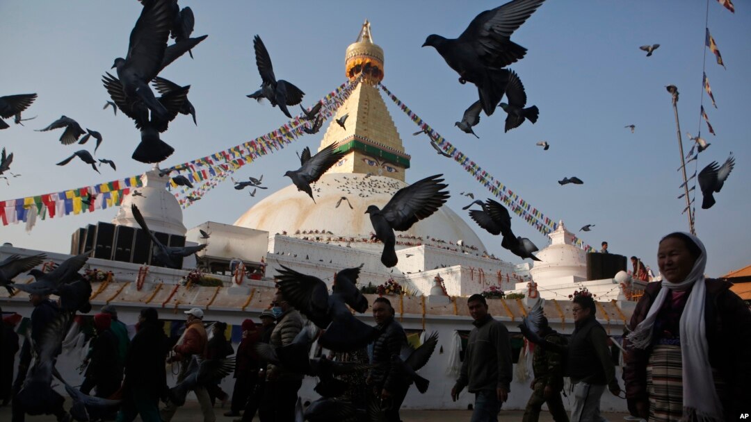 Burung merpati beterbangan di Stupa Boudhanath yang baru dibuka lagi untuk publik setelah restorasi pasca gempa di Kathmandu, Nepal (22/11). (AP/Niranjan Shrestha)