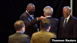 US Defense Secretary Lloyd Austin fist bumps Singapore Senior Minister Teo Chee Hean after speaking at the IISS Fullerton Lecture in Singapore, July 27, 2021.