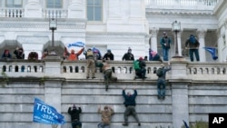 FILE - Supporters of President Donald Trump scale the west wall of the U.S. Capitol, in Washington, Jan. 6, 2021.