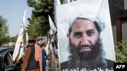 FILE - A poster of Taliban Supreme Leader Hibatullah Akhundzada is seen along a road in Kabul on Aug. 14, 2023. The International Criminal Court is seeking arrest warrants for Akhundzada and his chief justice.