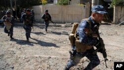 Iraqi security forces advance during fighting against Islamic State militants, in western Mosul, Iraq, March 6, 2017.