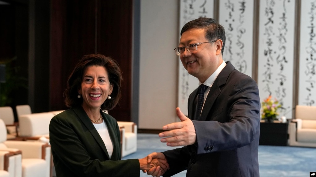 上海市委书记陈吉宁在与来访的美国商务部长雷蒙多会谈前与她握手。（美联社）(photo:VOA)