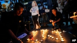 Thai activists hold candles during a vigil for Netiporn Sanesangkhom in Bangkok May 14, 2024. She went on a hunger strike after being jailed for her involvement in protests calling for reform of the country's monarchy system and died Tuesday in a prison hospital, officials said. 