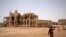 FILE - A man carries a table as he walks past the ruins of a building in the port city of Massawa, Eritrea, July 22, 2018. 