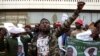 FILE - Supporters of Zambian President Edgar Lungu react while supporters of Zambia's opposition leader, Hakainde Hichilema, picket alongside Democratic Alliance (DA) members outside the High Commission of Zambia, in Pretoria, South Africa, Friday May 26, 2017. 