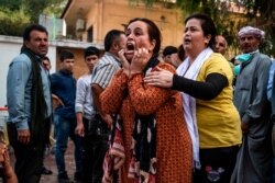 A woman reacts as the body of a man killed during Turkish shelling in the area surrounding the Syrian Kurdish town of Ras al-Ayn arrives at a hospital in Tal Tamr, Oct. 18, 2019.