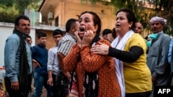 A woman reacts as the body of a man killed during Turkish shelling in the area surrounding the Syrian Kurdish town of Ras al-Ain arrives at a hospital in the nearby town of Tal Tamr, Oct. 18, 2019.