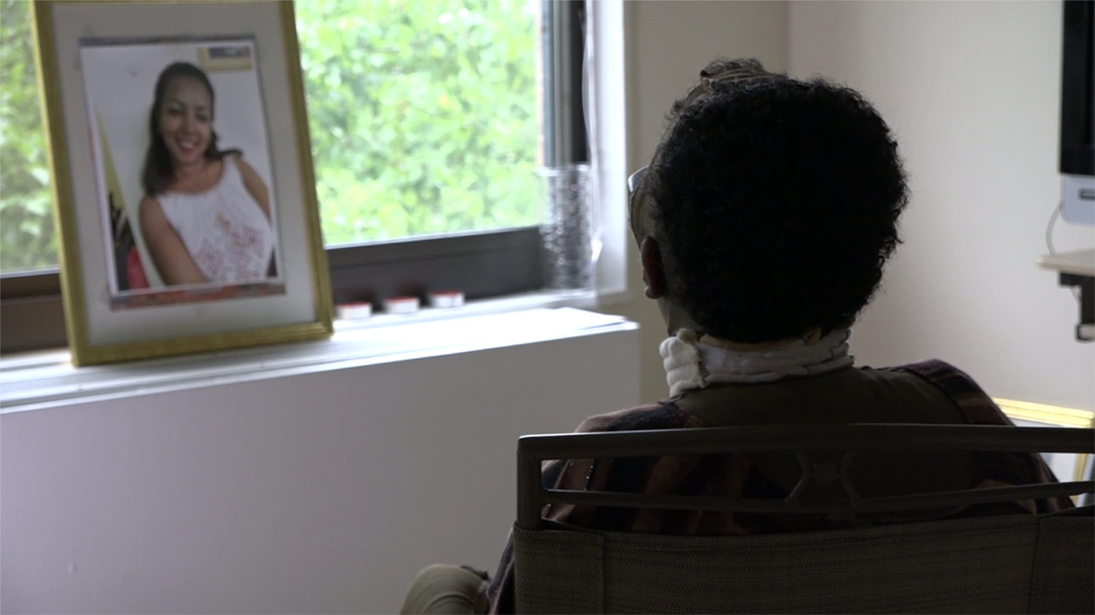 Selamawit Tefera sits by a window in this still frame from a video captured on Aug. 3, 2018. In February, Selamawit, an Ethiopian immigrant, was attacked by her roommate in Maryland. (Karina Choudhury/VOA News)