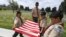 Boy Scouts from the Long Beach troop prepare a U.S. flag besides the graves of war veterans during the annual 'Flag Placement ceremony' to honor the fallen for Memorial Day at the Los Angeles National Cemetery, Calif., on May 25, 2019.