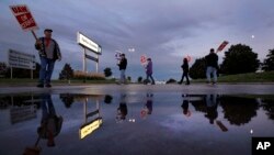 Varios empleados de General Motors protestan afuera de la Planta de Armado Fairfax en Kansas City, Kansas, durante la huelga general del sindicato UAW contra la empresa, el miércoles 9 de octubre de 2019. (AP Foto/Charlie Riedel).