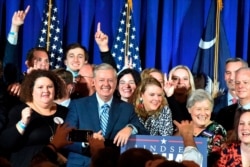 Supporters pose with U.S. Sen. Lindsey Graham, center, following his victory speech after winning another term in office on Nov. 3, 2020, in Columbia, S.C.