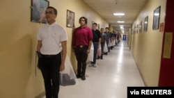 New U.S. Marines recruits use social distancing to stand in line, to help slow the spread of coronavirus disease (COVID-19), to receive their initial haircuts at Marine Corps Recruit Depot, San Diego, Calif., March 30, 2020.