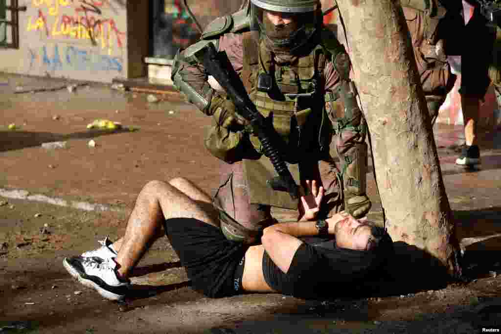 A policeman detains a demonstrator during a protest against Chile&#39;s government in Santiago, Chile, Nov. 13, 2019.