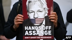 Pendukung dan aktivis memegang plakat di luar pengadilan Westminster Magistrates di London pada 20 April 2022, menyerukan agar pendiri WikiLeaks Julian Assange untuk dibebaskan. (Foto: AFP)