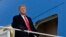 FILE - President Donald Trump pauses at the steps of Air Force One at Andrews Air Force Base in Maryland, Dec. 8, 2018. 