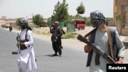 FILE - Former Mujahideen hold weapons to support Afghan forces in their fight against Taliban, on the outskirts of Herat province, Afghanistan, July 10, 2021. 