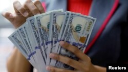 Seorang pegawai valas di perusahaan penukaran valas di Jakarta sedang menghitung uang dollar, 23 Oktober 2018. (Foto: Reuters)