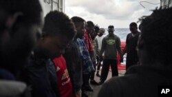 FILE - Migrants pray for Europe to grant them a place of safety as they travel aboard the Ocean Viking humanitarian ship in the Mediterranean Sea, Sept. 21, 2019. 