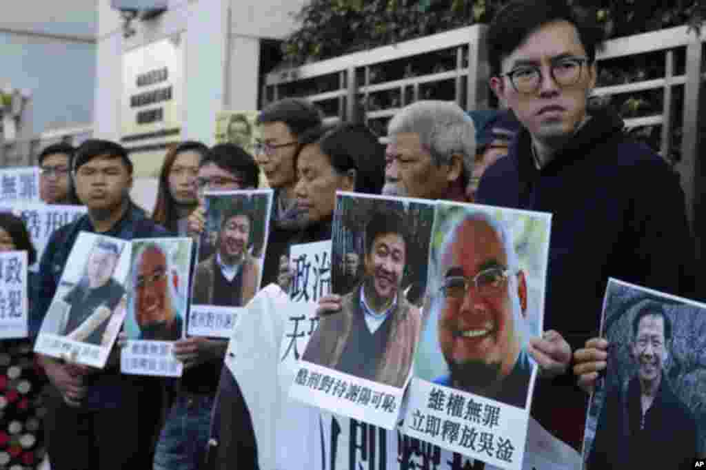 香港民主派活跃分子手持吴淦和谢阳等维权人士的照片在中国中央政府驻港机构中联办外面声援吴淦和谢阳等人（2017年12月27日）。其中古思尧（右二）12月29号因涉嫌去年亵渎国旗被警方预约拘捕。在去年10月的一次抗议中，社民连成员古思尧抬着一个时钟示威道具，上面的中国国旗被倒置，寓意&ldquo;为共和国送终&rdquo;。香港媒体报道说，古思尧还被控7月在中联办外焚烧中国国旗。