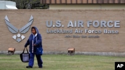 FILE - A pedestrian passes the main gate at Lackland Air Force Base in San Antonio, Texas, Feb. 5, 2020. The base was the site of gunfire between security guards and someone in a passing vehicle on Aug. 17, 2024.