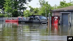 Two pickup trucks are seen surrounded by floodwater from the Mississippi River outside a garage in Memphis, Tennessee, May 8, 2011