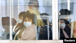 Warga Pyongyang, Korea Utara mengenakan masker saat naik bus, di tengah perebakan virus korona di negara tetangganya, Korea Selatan.