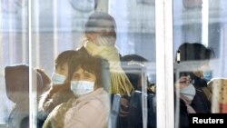 Passengers wear masks inside a trolley bus in Pyongyang, North Korea, Feb. 22, 2020, and released by Kyodo, Feb. 23, 2020.