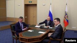 FILE - Russian President Vladimir Putin, center, then-Deputy Prime Minister of Russia Dmitry Kozak, left, are seen participating in a video conference in Sochi, Russia, Dec. 2, 2019. At right is Russian Energy Minister Alexander Novak.