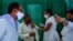 People wear masks as a precaution against the coronavirus as a health worker administers the COVISHIELD vaccine at a government hospital in Hyderabad, India, April 19, 2021.