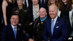 President Joe Biden, retired U.S. Army Col. Ralph Puckett and South Korean President Moon Jae-in, pose for a photo after Puckett was presented the Medal of Honor in the East Room of the White House.