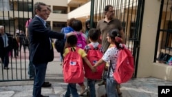  Refugee children enter a primary school in Athens on the first day of lessons under the new refugee schooling program on October 10, 2016. More than 60,000 refugees are stranded in Greece by European border closures.