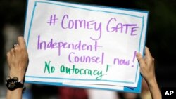 Seorang demonstran membawa tulisan dalam aksi demo terkait pemecatan James Comey di San Francisco, Rabu (10/5).