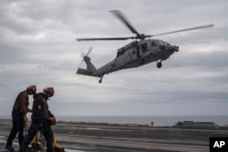 Angkatan Laut AS, MH-60S Sea Hawk, ditugaskan ke "Eightballers" dari Helicopter Sea Combat Squadron (HSC) 8, mendarat di dek penerbangan kapal induk kelas Nimitz USS Theodore Roosevelt (CVN 71) selama latihan Freedom Edge, pada Jumat, 28 Juni 2024. (Foto: via AP)