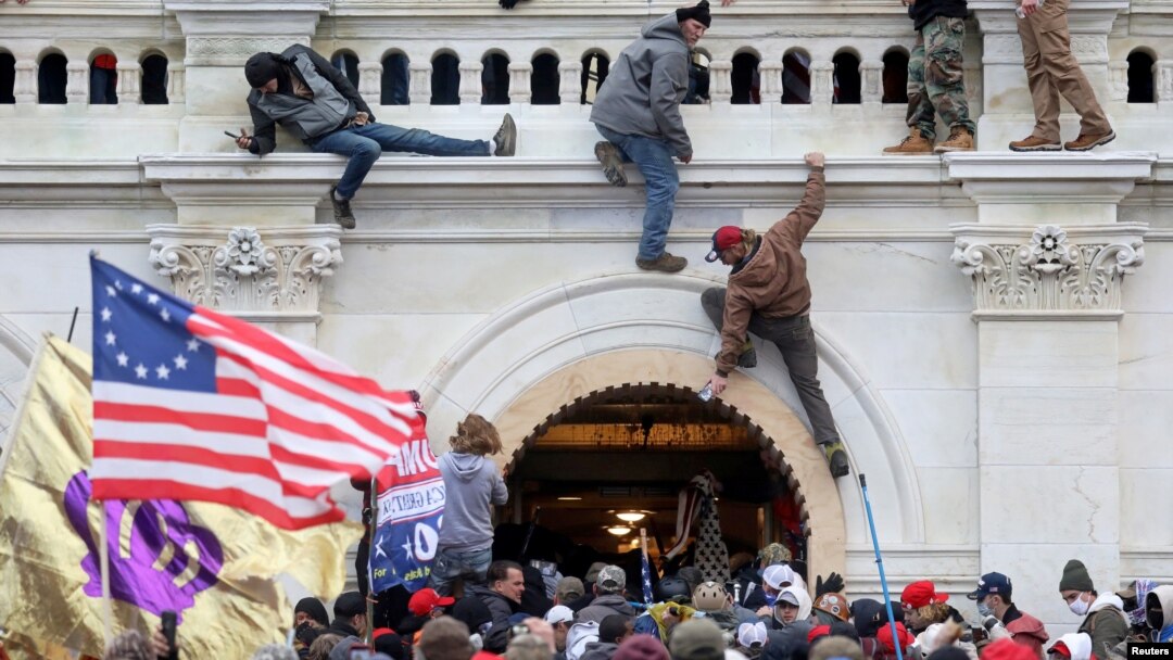 FILE - A mob of supporters of U.S. President Donald Trump fight with members of law enforcement at a door they broke open as they storm the U.S. Capitol Building in Washington, Jan. 6, 2021. 