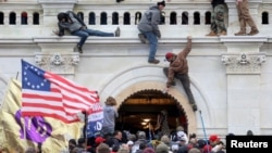 FILE - A mob of supporters of U.S. President Donald Trump fight with members of law enforcement at a door they broke open as they storm the U.S. Capitol Building in Washington, Jan. 6, 2021. 