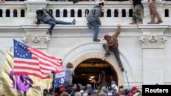 FILE - A mob of supporters of U.S. President Donald Trump fight with members of law enforcement at a door they broke open as they storm the U.S. Capitol Building in Washington, Jan. 6, 2021. 