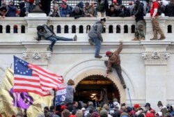 FILE - A mob of supporters of President Donald Trump fight with members of law enforcement at a door they broke open as they storm the Capitol Building in Washington, Jan. 6, 2021.